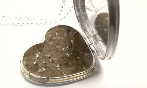 Srebrne serce-medalion z zawartością prochów, przypominające diament z prochów.