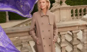 Elegancka kobieta w beżowym płaszczu, obok niej powiewa fioletowy szal z wzorem. Zastanawiasz się, jaki kolor pasuje do fioletu? Beż jest doskonałym wyborem!