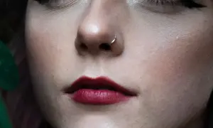 Delikatny kolczyk w nosie, ciemne usta i zielony liść. Ile goi się nostril?