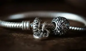 Srebrna bransoletka Pandora z charmsami, w tym charms z cyrkoniami i charms w kształcie serca.
