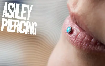 Ashley piercing na ustach z opalizującym kamieniem.