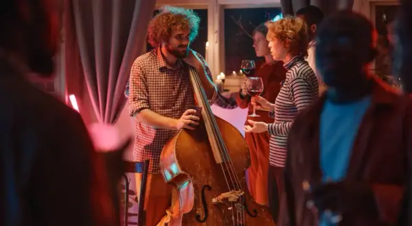 Muzyk z kontrabasem i goście z winem. Stylizacja na koncert jazzowy: swobodna elegancja.