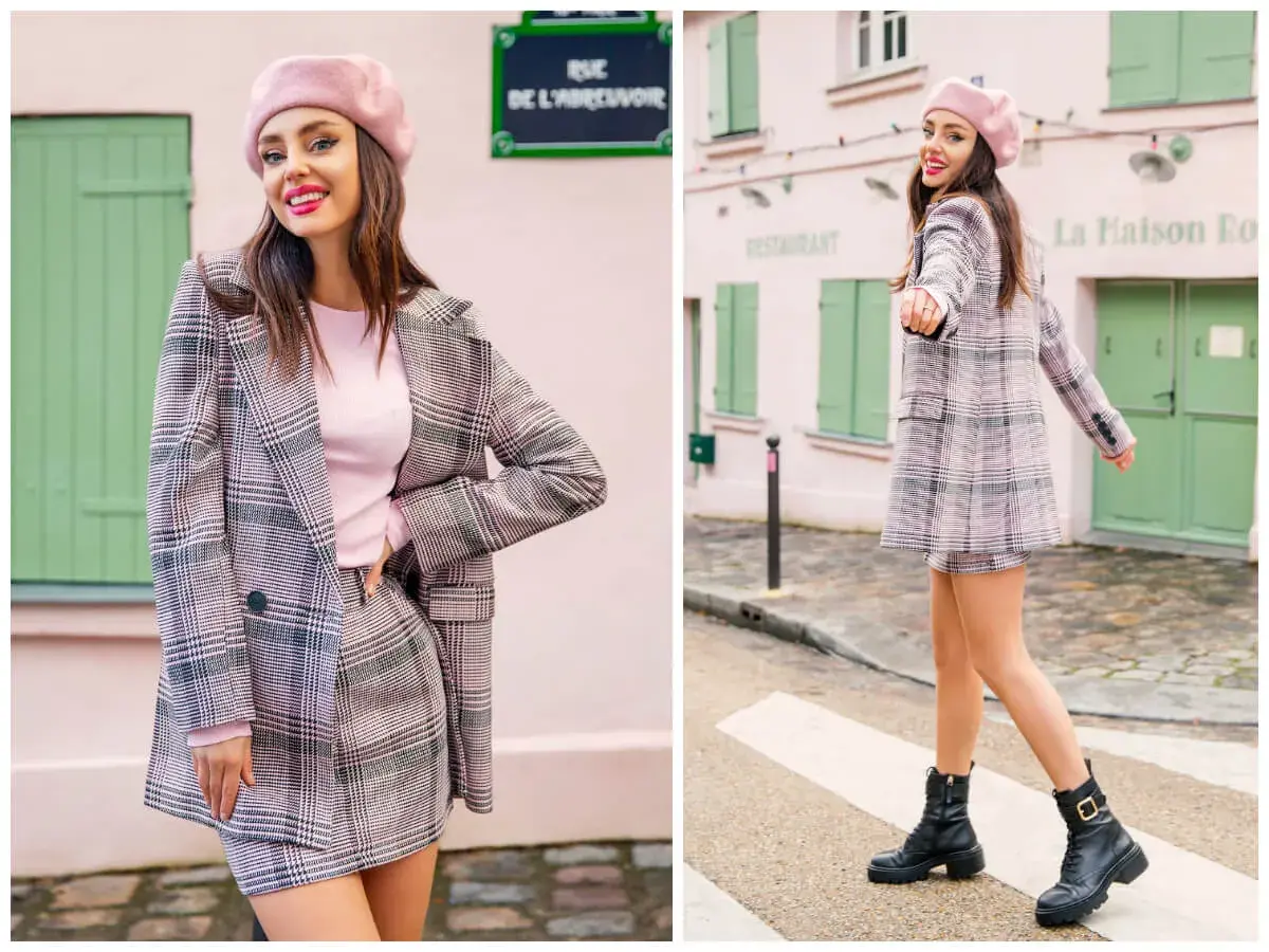 Dziewczyna w różowym beretce i kraciastej marynarce w stylu preppy, z mini spódniczką i botkami, pozuje na tle paryskiej uliczki.