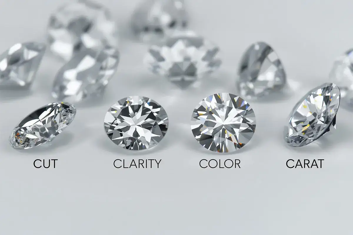 Cztery diamenty z etykietami: CUT, CLARITY, COLOR, CARAT. Dowiedz się, ile kosztuje diament.
