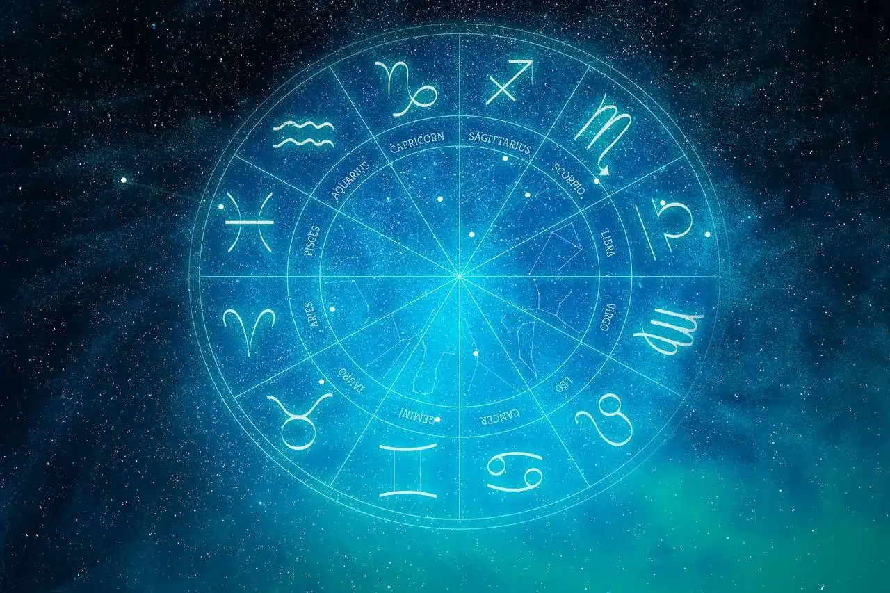 Koło zodiaku z symbolami znaków, jak kamień słoneczny, na tle rozgwieżdżonego nieba.