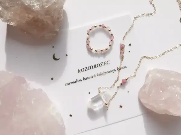 Delikatna biżuteria z różowych kamieni i kryształu, ozdobiona gwiazdkami i księżycem, nawiązuje do znaku zodiaku Koziorożec.