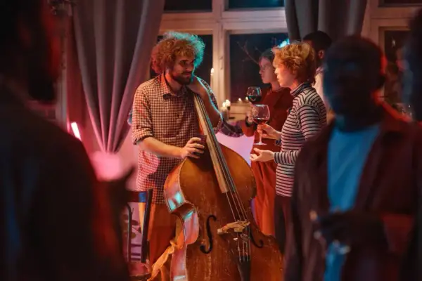 Muzyk z kontrabasem i goście z winem. Stylizacja na koncert jazzowy: swobodna elegancja.